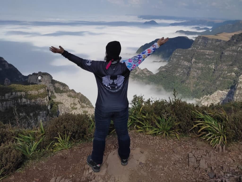 Telma aprecia a bela vista da Serra do Rio do Rastro coberta por nuvens. Foto: Filhas do Vento/ Divulgação